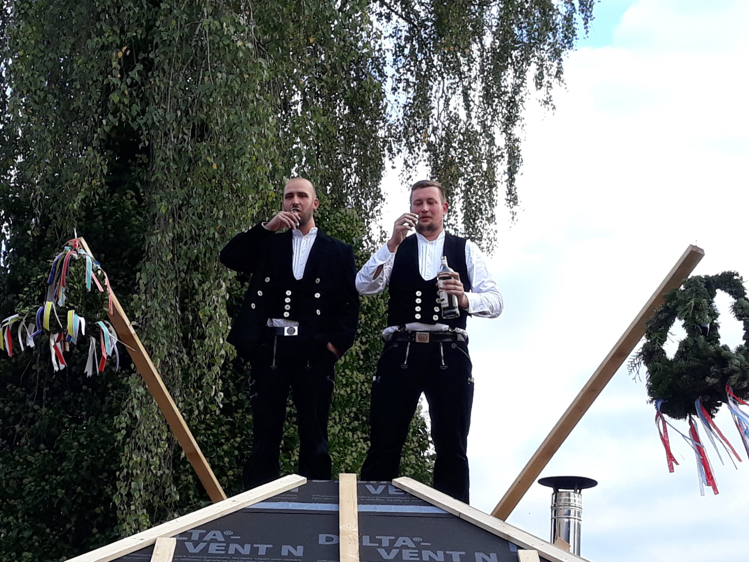 Handwerker beim Richtfest auf dem Dach